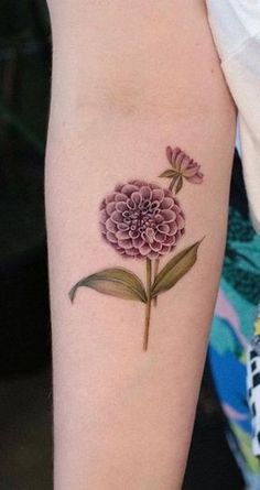 a woman's arm with a pink flower tattoo on the left side of her arm