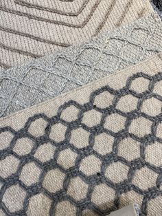 four different colors of knitted fabric on the floor, including one gray and one white