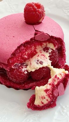 raspberry cake with cream filling and fresh raspberries in the middle on a white plate