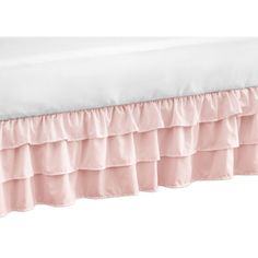 a bed with pink ruffled bedspread and white sheets on the bottom half