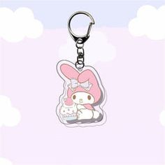 a hello kitty keychain is shown on a pink and white background with clouds