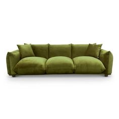 a green couch with four pillows on the back and one arm folded out to show it's curved shape