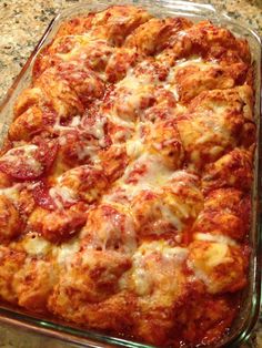 a casserole dish with meatballs and cheese in it sitting on a counter