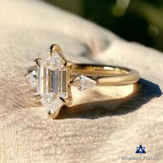 a diamond ring sitting on top of a white cloth