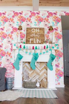 a living room with a fireplace and floral wallpaper on the walls, stockings hanging from the mantel