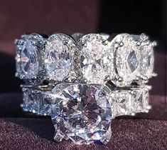 a diamond ring is shown on top of a cushioned surface with other rings surrounding it