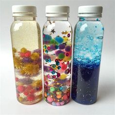 three glass bottles with different designs on them