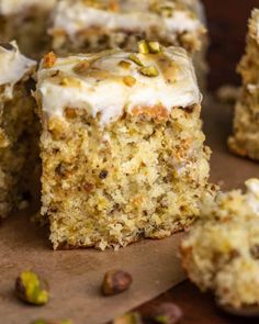 there are pieces of cake with white frosting and nuts on the table next to it