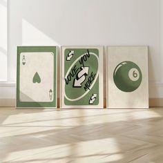 three green and white playing cards sitting on top of a hard wood floor next to a window