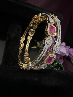 Ruby Pink AD Stones Bangles Set Off 2/Gold Finish Ruby Bangles / South Indian Jewelry DETAILS: Includes Two Bangles  Red Ruby AD Stones . Material: Artificial Gold and Ruby Stones. Finish: Premium Micro Gold finish.  BANGLE SIZES & WEIGHTS: Approxment  1.85 oz ( 54g) SET Off Bangle. Size 2-4: Inner diameter 2.24 inches.  Size 2-6: Inner diameter 2.37 inches.  Size 2-8: Inner diameter 2.5 inches.  NOTE: We try our best to show you photos of our items as they appear in real life, but please note t Luxury Red Ruby Bangle, Luxury Ruby Chandbalis For Wedding, Stackable Bangle For Parties, Red Hoop Jewelry For Festive Occasions, Festive Red Hoop Jewelry, Red Round Bangle For Party, Red Hoop Jewelry For Wedding, Elegant Red Stackable Jewelry, Red Hand Set Bangle For Party