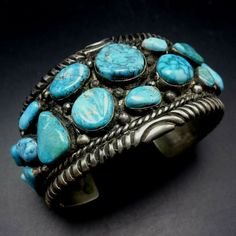 "VINTAGE NAVAJO BRACELET DESCRIPTION: This impressive cuff features 21 specimens of blue Arizona turquoise.. The gemstones are secure in smooth bezel, on a foundation of heavy gauge vintage sterling silver. Plump applied raindrops punctuate the turquoise cabochons and chisel stamped designs frame the edges. This fine bracelet will be a cherished addition to your collection of fine vintage Native American jewelry. MEASUREMENTS: Interior of the cuff measures 5 7/8\" with an additional 1 1/4\" non- Handmade Turquoise Vintage Cuff Bracelet, Vintage Turquoise Bangle Cuff Bracelet, Vintage Blue Bangle Bracelets, Vintage Blue Bracelet For Formal Occasions, Vintage Blue Cuff Bracelet, Vintage Turquoise Cuff Bracelet, Vintage Blue Cuff Jewelry, Blue Collectible Cuff Bracelet Bangle, Blue Unique Cuff Bracelet For Formal Occasion