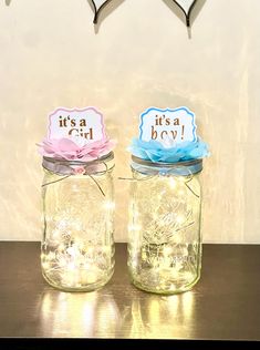 two mason jars sitting on top of a table next to each other with tags in them