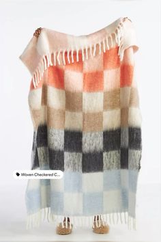 an orange, black and white checkered blanket with fringes