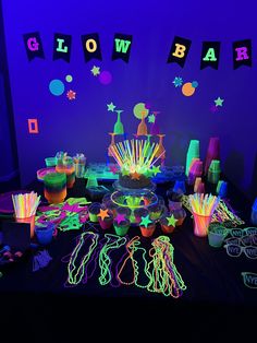 neon glow party supplies and decorations on a table