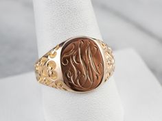 Carved designs and fleur de lis motifs on the shoulders bring a touch of elegance and distinction to this vintage signet ring. The gold is solid, making this easy to wear every day. The script style of the monogram suits the style of the ring beautifully! Please note that this signet ring has its original monogram, and unfortunately, this piece cannot be altered without affecting the quality of the piece. Please feel free to contact us to help you find your perfect signet ring in your style and Antique Gold Signet Ring With Intricate Design, Antique 14k Gold Signet Ring With Intricate Design, Antique Carved Yellow Gold Signet Ring, Elegant Yellow Gold Signet Ring With Hallmarks, Antique Coin-shape Engraved Signet Ring, Engraved Signet Ring, Carved Designs, The Script, The Ring