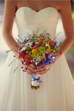 a woman holding a bouquet of flowers in her hands