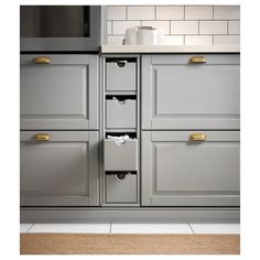 a kitchen with gray cabinets and white counter tops, gold pulls on the drawer handles