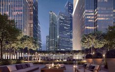 an outdoor living area with couches and tables in the foreground, surrounded by tall buildings