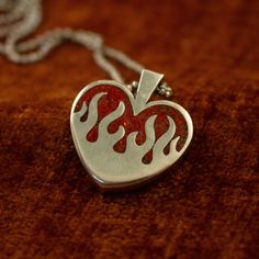 The silver hearts on fire pendant features a chunky design and a stunning ruby red opal inlay (or your chosen stone). Alternatively, you can opt for a transparent pendant without any inlay. It boasts a substantial 4 mm thickness and stands 26 mm tall. PLEASE READ: The production and delivery of your piece may take anywhere from 2-4 weeks as it is custom made by a real person. Grit Trade Co. is a curated collection of unique sterling silver jewelry inspired by American culture, music, and motorcy Red Heart-shaped Engraved Jewelry, Red Engraved Heart-shaped Jewelry, Red Sterling Silver Jewelry With Inlay, Red Sterling Silver Heart Pendant Jewelry, Unique Red Heart Shaped Jewelry, Red Polished Jewelry For Valentine's Day, Collectible Heart-shaped Jewelry For Valentine's Day, Unique Sterling Silver Jewelry For Valentine's Day, Red Sterling Silver Jewelry With Polished Finish