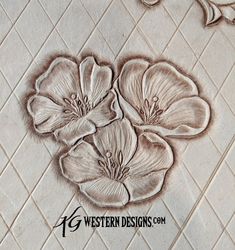 some flowers that are on the ground in front of a tile wall with words western designs