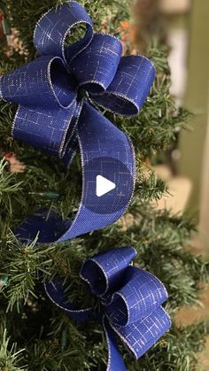 a close up of a blue bow on a christmas tree