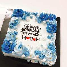 a happy birthday cake with blue flowers and white frosting on it's side