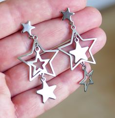 Asymmetric stainless steel star charm and star stud earrings. These earrings are made of stainless steel only. Earring length: 52mm, 2" Charm material: stainless steel Earring stud material: stainless steel Backs: rubber This listing is for 1 pair of asymmetric star charm earrings.  These earrings will come in a gift bag. I offer combined shipping costs which give you a shipping discount for ordering multiple items from my shop. Please note: this item will be sent for free via standard unregistered post, without a tracking number.  If you would like to be registered during checkout you can choose to upgrade to registered postal service. See more chain/cord/wire click here: http://etsy.me/2qSGJ6b Don't forget to purchase the matching set of bails, clasps, necklace/bracelet connectors click Bracelet Connectors, Stainless Steel Earrings Studs, Star Stud Earrings, Jewelry Accessories Ideas, Earring Stud, Star Earrings Stud, Funky Jewelry, Star Studs, Jewelry Inspo