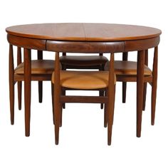 a wooden table with four chairs and a small round dining table on one side,