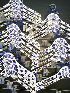 a bunch of toothbrushes that are hanging on a rack with name tags attached to them