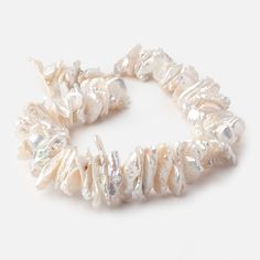 a bracelet made out of white pearls on a white surface with silver beads around it