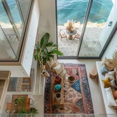 an aerial view of a living room with couches, rugs and potted plants