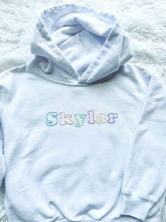 Personalized hand embroidered hooded sweatshirt.  Created on a white hooded sweatshirt with simple stitching in an array of pastels.  A name, location or a simple word all work great for this custom design.  This listing is for one single name or word only.  Please contact me if you're looking to add additional text before ordering.  Each sweatshirt is hand embroidered, made to order and customized to your preferences to create a one-of-a-kind item.  These sweatshirts make for a thoughtful, unique and special gift.  I will be using white unisex  hooded sweatshirts.  Please reference the toddler and youth size charts pictured for measurements.  If you'd like a different sweatshirt color option please send me a message and I will try to accommodate!   In the personalization box please includ Spring Cotton Hoodie With Embroidered Logo, White Cotton Hoodie With Embroidered Logo, Spring Hooded Sweatshirt With Embroidered Logo, White Hoodie With Embroidered Logo, White Hoodie With Embroidered Logo Long Sleeve, White Long Sleeve Hoodie With Embroidered Logo, Casual Hoodie With Machine Embroidery For Streetwear, White Crew Neck Hoodie With Embroidered Logo, Casual Embroidered Hoodie For Streetwear