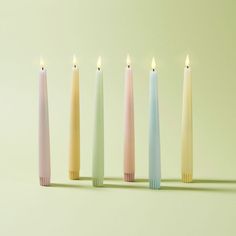 five different colored candles lined up next to each other