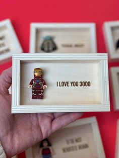 a person holding up a lego minifigure in a box with the words i love you 30000 on it