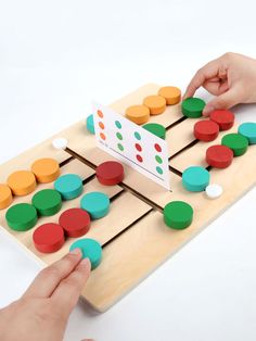 two hands are playing with a wooden board game