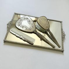 a silver tray with three different types of hairbrushes and combs on it