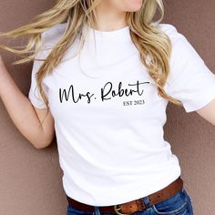 Personalised Mrs t-shirt with last name and established date This Mrs T-shirt is perfect for the bride-to-be. It features her last name and their established date, making it a meaningful and personal gift that can be worn at the wedding and beyond. It's also a great honeymoon gift. Future Mrs Shirt, Honeymoon Gift, Mrs Shirt, Honeymoon Gifts, Gift For Bride, Future Mrs, Cotton Gifts, Bride Gifts, Hen