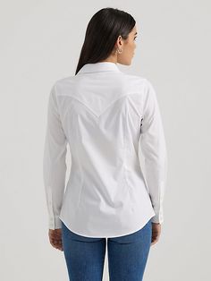 CLASSIC AND ICONIC You’ll look sharp and ready to conquer the world in our Women’s Wrangler Retro® Western Button-Down Shirt. It’s crafted from a comfortable cotton blend with just a hint of stretch. It comes with our signature chest flap pockets and “W” stitching as well as Western yokes, a pointed collar, and a full button closure for easy layering. Get one for every day of the week. Fitted Cotton Shirt For Rodeo, Fitted Western Style Cotton Shirt, Western Style Cotton Workwear Tops, Fitted Cotton Top For Rodeo, Cotton Tops With Snap Buttons For Rodeo, White Long Sleeve Shirt Western, Fitted Cotton Western Top, Classic Button-up Top For Rodeo, Western Style Cotton Button-up Tops