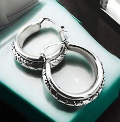 Elevate your jewelry collection with our exquisite 925 Sterling Silver Caviar Design Hoop Earrings. These elegant earrings showcase a sophisticated latch-back closure, ensuring both security and comfort. The hollow form construction provides a lightweight feel without compromising on style. Each earring is meticulously crafted to measure approximately 1.078 inches (27.5 mm) in width and 1.047 inches (26.6 mm) in length, offering a substantial presence while maintaining an air of delicacy. The caviar design adds a touch of luxury and texture, making these hoops a versatile addition to any outfit, whether casual or formal. Proudly stamped with '925' to affirm the purity of the silver used, these earrings are a testament to quality craftsmanship and enduring design. Elevate your accessory the Silver Engraved Hoop Earrings For Anniversary, Engraved Silver Hoop Earrings For Anniversary, Sterling Silver Engraved Hoop Earrings For Anniversary, Engraved Sterling Silver Hoop Earrings For Anniversary, 925 Stamped Small Hoop Earrings For Anniversary, Small Hoop Engraved Sterling Silver Earrings, Engraved Small Hoop Sterling Silver Earrings, Small Engraved Sterling Silver Hoop Earrings, Silver Hallmarked Hoop Earrings For Anniversary