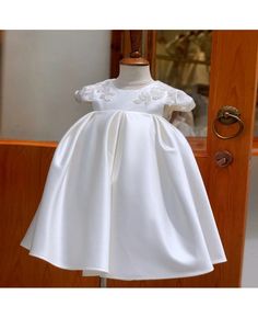 a white dress on display in front of a door