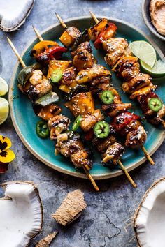 chicken kabobs on skewers with lime wedges