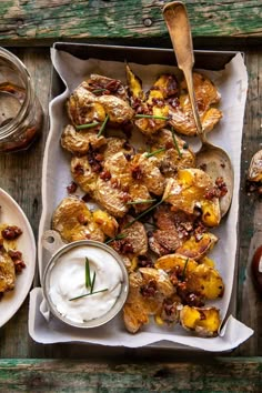 an overhead view of some food on a wooden table with two bowls and spoons