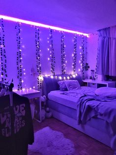 a bedroom with purple lights on the wall and bed in the center, along with white rugs