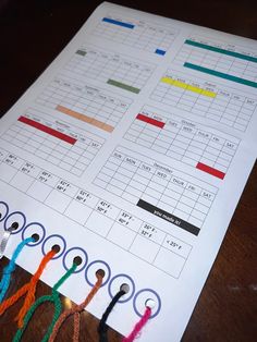 a table with several different colored yarns on it and a paper that has an activity sheet attached to it