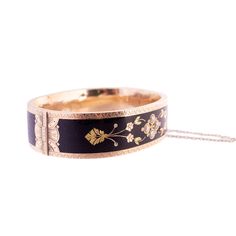 An antique hinged bangle bracelet with black enamel and a floral motif Seed pearls 10k yellow gold with green and rose gold Victorian The inside diameter is 2.25" This bracelet shows wear, the inside has quite a few dings and light scratches. The enamel is slightly abraided as well but overall the piece is still in good condition. 30.5 grams Elegant Enamel Cuff Bracelet For Formal Occasions, Black Heirloom Jewelry For Ceremonial Use, Black Heirloom Jewelry For Ceremonial Occasions, Black Heirloom Ceremonial Jewelry, Heirloom Hinged Bangle As Gift, Heirloom Hinged Bangle Gift, Wedding Enamel Bangle Jewelry, Victorian Bangle Bracelets For Formal Occasions, Elegant Black Enamel Cuff Bracelet Bangle Style