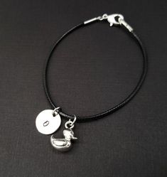 Personalized Waxed Cord Bracelet!  A three dimensional rubber duck charm on a black waxed cord makes the perfect gift for your best friend.The duck charm is made from zinc alloy and measures 12 mm by 5 mm.  The charm is reversible.  The bracelet is a waxed braided rope and measures 7.25" with a 1-2" extender (see last picture).  The lobster clasp is zinc alloy.  The black cord bracelet can be personalized with a .5" silver plated disc stamped with the initial of your choice.  Each personalized b Adjustable Nickel-free Black Charm Bracelet, Adjustable Black Bracelets With Charms, Adjustable Black Novelty Charm Bracelet, Black Adjustable Charm Bracelet, Novelty Style, Black Novelty Bracelet Jewelry, Nickel-free Black Charm Bracelet For Gift, Nickel-free Black Charm Bracelet As Gift, Adjustable Black Charm Bracelet With Lobster Clasp, Duck Bracelet