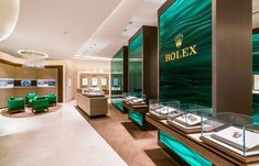 a jewelry store with green chairs and glass displays on the wall, along with other jewelry items