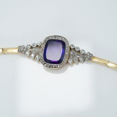 Art Deco Amethyst and Diamond Bracelet in 15 carat yellow gold and platinum, circa 1930's.  This absolutely stunning bracelet features a rectangular amethyst of the most vibrant purple surrounded by a halo of diamonds set in a platinum millegrain channel to form a rounded rectangle. The lower part of this setting features decorative engraving. Each side of the bracelet is articulated and set with eight diamonds in a pyramid shape topped with five further diamonds set in the shape of a flower. Al Elegant Purple Jewelry With Polished Finish, Formal Purple Jewelry With Polished Finish, Amethyst Fine Jewelry For Evening, Timeless Purple Jewelry For Formal Occasions, Elegant Rectangular Jewelry With Single Cut Diamonds, Vintage Amethyst Jewelry With Polished Finish, Formal Rectangular Bracelet In Fine Jewelry Style, Formal Fine Jewelry Rectangular Bracelet, Fine Jewelry Rectangular Bracelet For Formal Occasions