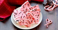 some candy bars are on a plate with pink and black sprinkles next to them