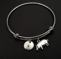 Personalized Antique Silver Pig Bangle Bracelet!  A sweet pig with a curly tail charm on an expandable bangle bracelet makes the perfect gift for you or your best friend.The pig bracelet charm is made from zinc alloy and measures 20 mm by 12 mm.  The bangle bracelet is high quality stainless steel and fits a wrist sized 6-8".  The pig bangle bracelet is personalized with a .5" silver plated disc stamped with the initial of your choice.  The charm and initial disc are connected to the bangle with Nickel Free Novelty Bracelet Jewelry, Cute Adjustable Bangle Jewelry, Pig Bracelet, Animal Bracelet, Expandable Bangle Bracelet, Bracelet Charm, Charm Bangle, Bangle Bracelet, Alex And Ani Charm Bracelet